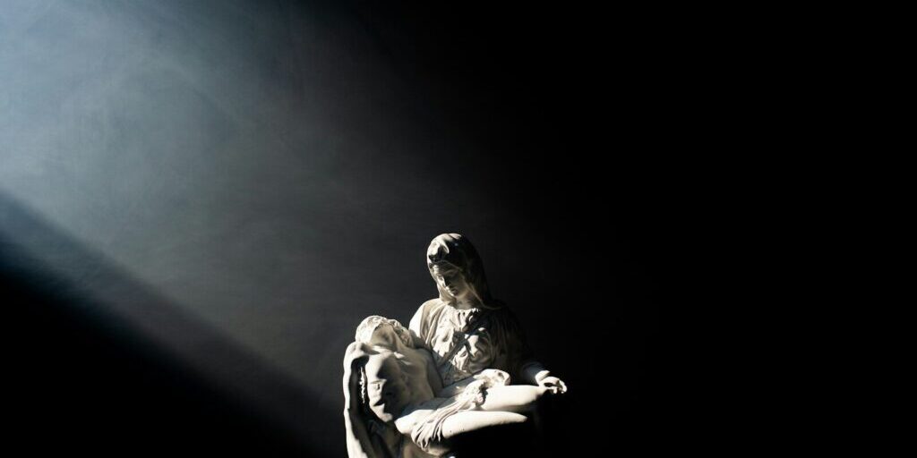 man in white and black jacket and pants sitting on black surface