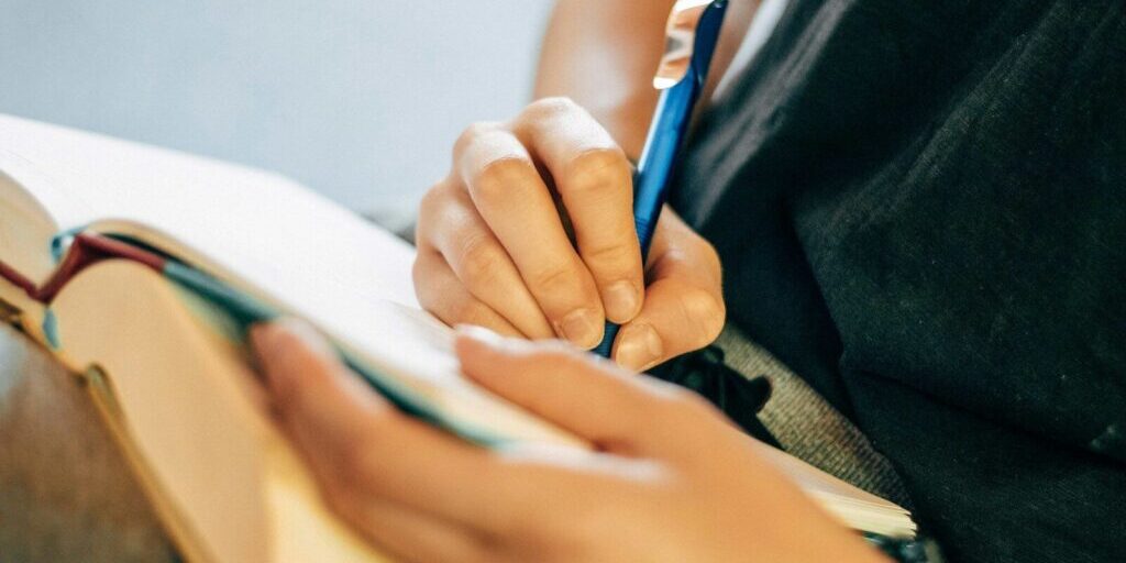 shallow focus photo of person writing